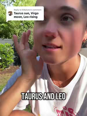 The cover image displays a close-up of a young woman, who appears to be filming herself with a mobile device. She has fair skin, dark hair, and is wearing a white t-shirt. She is positioned slightly off-center, with the right side of her face filling the frame and her right hand raised near her face. In the background, there's a suggestion of a green, outdoor environment, potentially a park or backyard. A text overlay with the words "TAURUS AND LEO" at the bottom. A comment overlay from a user is also visible in the top-right corner.