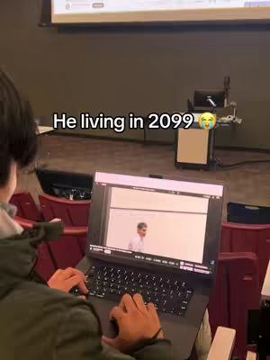 A person is seen in a classroom, typing on a laptop. The laptop screen displays a presentation. Overlay text indicates the video's theme. The background shows a lecture hall setting.