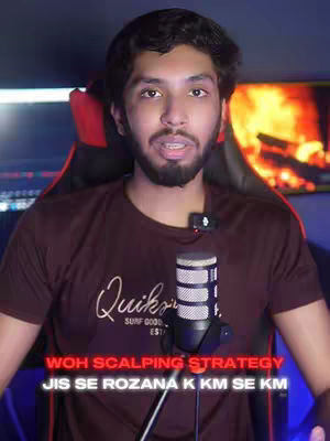 A man with a beard and dark hair is in a well-lit room with a microphone in front of him. Text overlays are added to the image. In the background is a blurred display with orange and blue lights.