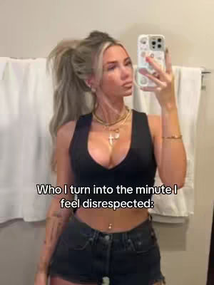 A woman is taking a selfie in what appears to be a bathroom. She is wearing a black top and jean shorts, and has blond hair in a high ponytail. The text on the image says: 'Who I turn into the minute I feel disrespected'.