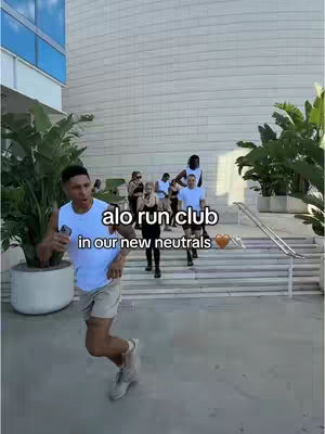A group of people are running down a set of stairs in front of a building. Text overlay indicating the video is related to a run club, with branding and text at the bottom of the frame.