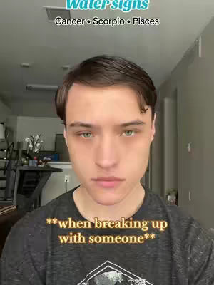 A medium shot of a young man looking directly at the camera in a home setting. Above his head, text in a teal box indicates the video is about zodiac signs. The man has short, dark hair and a neutral expression. Overlaid at the bottom is text in a gold hue. The background is softly blurred, with glimpses of a kitchen and living space visible. The overall composition is straightforward, with the man as the central focus.