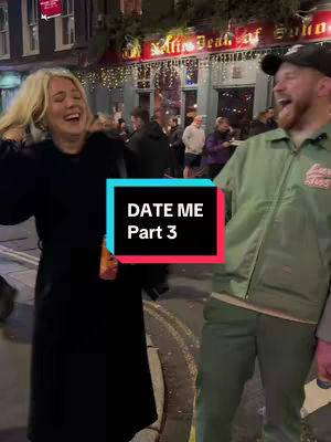 A candid shot of a woman and a man laughing outdoors with a bar in the background. The woman, on the left, is wearing a black coat, while the man on the right is wearing a green jacket and a cap. They are both joyful, with the woman's arms raised. A text overlay reads 'DATE ME Part 3'.