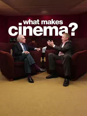 The cover image shows a shot of two men seated, engaged in conversation. They are positioned in a room with a dark red panelled wall in the background, and the overlay text "what makes cinema?" is positioned at the top in a bold, white font.