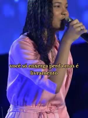 A woman with long dark hair is singing into a microphone. The image has a pink and blue color scheme. There's text overlayed on the image.