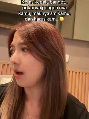 A woman with long, reddish-brown hair looks slightly off-camera with an open mouth as if she is speaking. Text overlay is visible at the top of the frame.