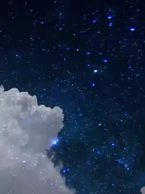 A celestial scene featuring a dark blue night sky filled with multiple twinkling stars, suggesting a vast, open space. A large, fluffy white cloud partially obscures the lower-left portion of the frame, its soft texture contrasting with the sharp points of light from the stars.