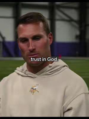 The image shows a man in a tan hoodie against a blurred background of what appears to be a sports field. Text overlayed on image says 'trust in God.'