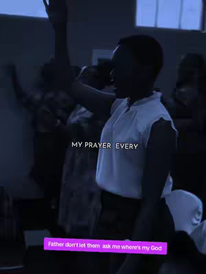 The image captures a moment of worship or spiritual expression with a woman raising her arm in a church setting. The lighting is dim, creating a somber mood, and the background is blurred with other people, also with their arms up. Text overlays include 'MY PRAYER EVERY' at the top and a purple rectangle with additional text at the bottom.