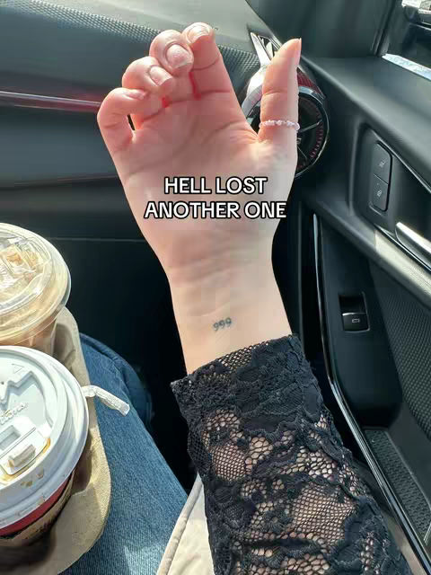 The cover image features a close-up of a person's hand inside a car, with a black lace sleeve visible. The hand is raised, displaying a small tattoo of the number "999" on the wrist and a ring on the finger. A white text overlay reads "HELL LOST ANOTHER ONE". The background inside the car is visible.