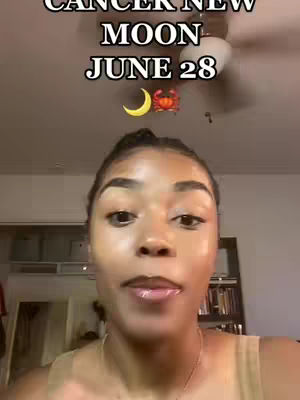 A woman with dark hair is centered in the frame. Behind her, a ceiling fan and a mirrored closet door are visible. Text overlaid says CENCER NEW MOON JUNE 28, with a crescent moon and crab symbol. The woman is looking at the camera.