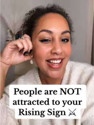 A selfie-style video cover featuring a woman up close, smiling and gesturing towards her earring with her right hand. She has dark curly hair and is wearing makeup. The background is blurred, and a white rectangle with black text overlays the image.