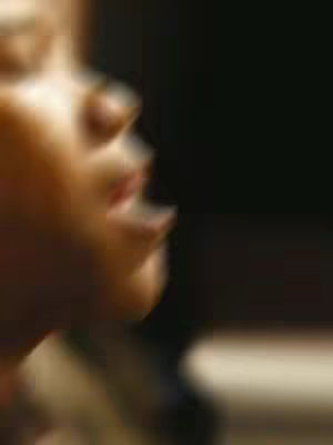 An out-of-focus side profile view in soft, warm tones. The blurred image shows a person's face with prominent features like a nose and partially visible lips, suggesting a close-up emotional portrait.