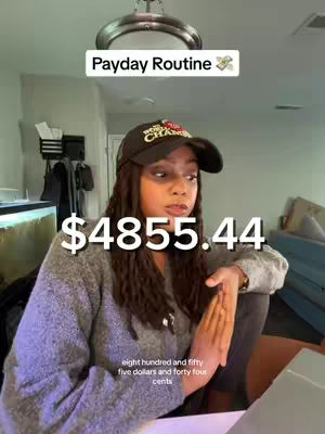The cover image features a woman in a cap and sweater. She is looking towards the left with a slightly concerned or thoughtful expression. Overlaid are large bold numbers representing an amount of money. The background shows a domestic setting possibly the interior of a home, with overhead lighting and other objects that may be part of the room's furniture or decorations. The general feel conveys financial context.