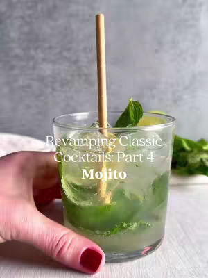 The cover image features a close-up of a glass of mojito, with a hand holding the glass. The drink is filled with green mint leaves and ice, and a wooden straw is inserted into it. Text overlaying the image reads: "Revamping Classic Cocktails: Part 4 Mojito". The background blurs into a light gray, accentuating the vibrant colors of the drink.