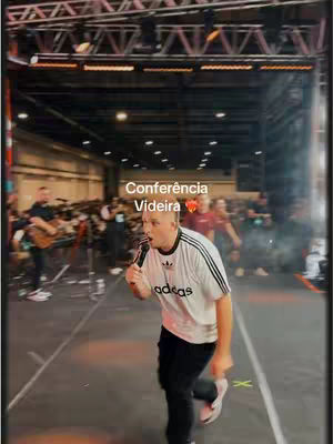 The cover image shows a man on a stage, holding a microphone and appearing to sing or speak. The background suggests a large indoor venue, possibly a conference center or auditorium, with a crowd of people. Text overlay indicates the name of the event.
