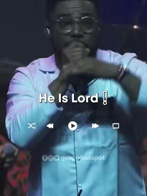 A man wearing glasses and a white shirt is shown from the chest up, with his hands near his mouth. Above him in a white banner is the text 'He Is Lord!', with an exclamation point. Below, there are video player controls and the Gospel Hotspot logo.