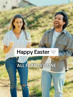 A cover image of two people, a woman and a man, standing outside on a sunny day. The woman is on the left and the man is on the right, both looking towards each other smiling. Text overlays say Happy Easter and All Fear Is Gone, which is in a white banner.