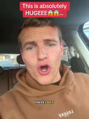 A man with short blonde hair, wearing a brown hoodie in a car, looking excited with his mouth open wide. The top of the image features a red bar with white text, and the bottom has a black bar with more text.