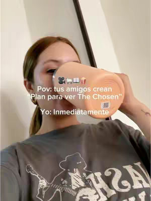 The image highlights a woman holding up a peach-colored tumbler, obscuring her mouth. She is wearing a gray t-shirt. Text overlays with icons are positioned above the tumbler. The background includes a light-colored wall and a dark vertical panel, possibly a mirror.
