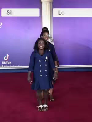 The cover image shows four black females standing in a line, seemingly in a church setting. The woman in the front wears a navy dress and smiles at the camera, while the others stand behind her, also dressed in navy. A pillar and a purple background is visible. The video has a TikTok logo.