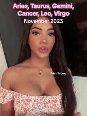 The cover image features a woman with long dark hair gazing directly at the camera. Text overlays include astrology-related information. The upper section has the zodiac signs 'Aries, Taurus, Gemini, Cancer, Leo, Virgo' in pink font, followed by 'November 2023'. In the bottom right corner, 'Aries Taurus' is written. The woman is wearing an off-the-shoulder floral top, has noticeable makeup, and a necklace.