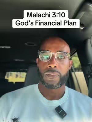A man sitting in the driver's seat of a car. The man is wearing glasses and a white shirt, and there is text overlaid on the top of the image.