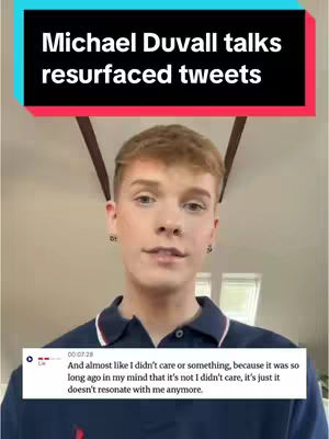 A young man with light hair and fair skin is centered in the frame, wearing a dark blue polo shirt. A text overlay in a black and red box at the top reads "Michael Duvall talks resurfaced tweets". A lower text box appears with a comment and a timestamp.