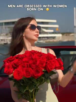 The cover image shows a woman in sunglasses holding a large bouquet of red roses. The background appears to be a sunny outdoor scene, possibly near a building. The woman is wearing a light-colored top, and the overall composition focuses on her and the roses.
