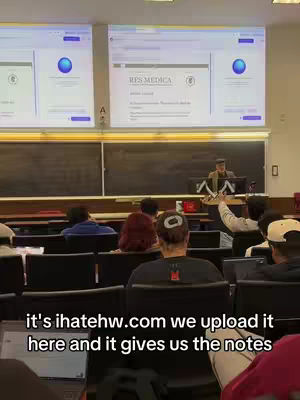 The cover image shows a classroom setting with several students and a teacher. Two large screens display a website with a logo. The foreground features the back of a student's head. The scene is likely from a lecture or study hall.