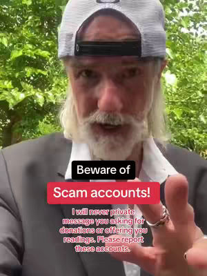 A man with long white hair and a beard wearing a gray blazer and a white cap, is talking to the camera standing outside, with green foliage in the background. Overlay text is displayed on a red background: "Beware of Scam accounts! I will never private message you asking for donations or offering you readings. Please report these accounts."