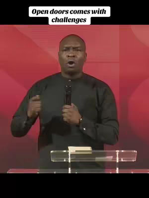 The cover image features a man, likely a preacher or speaker, centered against a red background. He is wearing a black shirt and holding a microphone. Text in a white box at the top reads 'Open doors comes with challenges'. A lectern is in front of him.