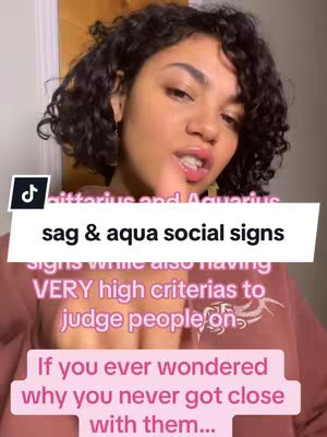 A woman with curly dark hair is centered in the frame, facing the camera and talking, with overlaid text boxes. The background includes glimpses of a door and wall, but the focus is on the woman and the text overlay.