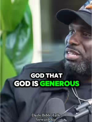 A close-up shot of a Black man with a beard wearing a black cap. Text overlays read, 'GOD THAT' and 'GOD IS GENEROUS'. A microphone is visible in the bottom center, and a blurred green background is slightly visible on the upper left.