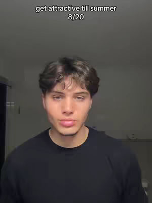 A young man with dark hair is centered, facing the camera. He wears a black t-shirt. Above him, text reads, 'get attractive till summer 8/20'. The background is a nondescript light gray.
