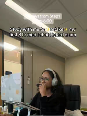 A person wearing glasses and headphones sits in an office setting with a laptop open in front of them. Text overlays indicate the video is about studying for a medical board exam.