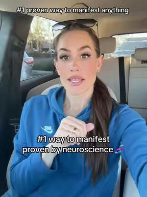 A woman in a blue hoodie is seated inside a car. Text overlays are added. Sunglasses rest on her head and she appears to be talking to the camera.