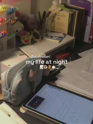 A photo of a desk with a tablet, papers, and stationery, suggesting a study or work environment. The overall color tone is warm and inviting, with a focus on the items on the desk. White desk with books, pen pencils and a tablet at the bottom