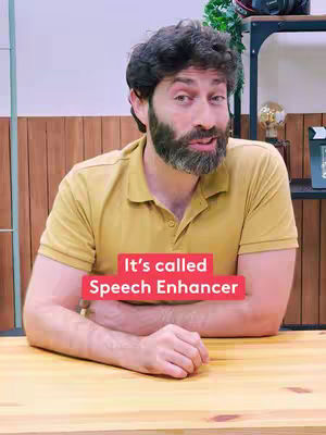 A man with a beard is sitting at a wooden table, facing the camera. The text overlay on the image says "It's called Speech Enhancer" on a red background.