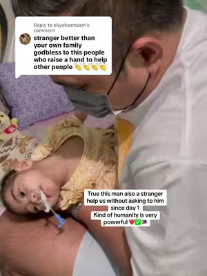 The image shows a man in a white shirt wearing a face mask, looking down at a young child who is lying on a bed. The child has medical tubes in their nose and mouth. Text bubbles and captions are overlaid on the image, with additional text highlighting themes of kindness and support.