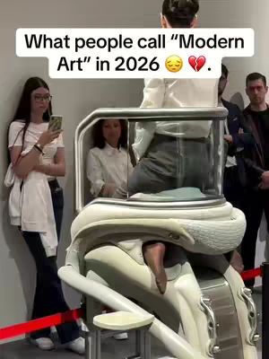The cover image features a modern art installation with several people interacting with it. A woman in a white shirt and glasses looks at her phone on the left. In the center, a person is seated within a transparent, futuristic pod-like structure. The composition includes a light-colored, possibly metallic, stand or sculpture. The scene is set in what appears to be a white-walled gallery.