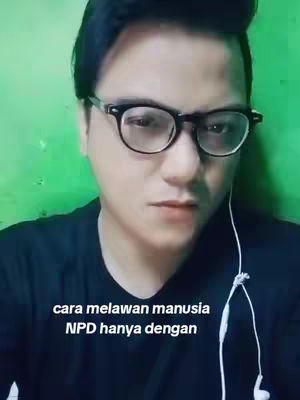 A man with glasses looks at the camera, green wall behind him and text overlayed at the bottom