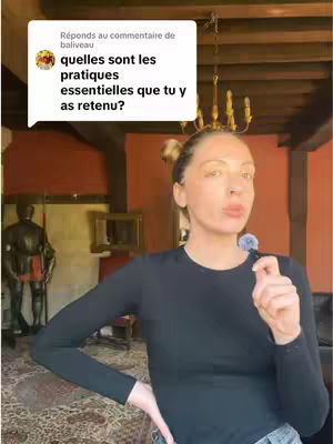 A woman is standing in front of an older-style paneled interior with a patterned rug. She is holding a small microphone and is speaking directly, with a speech bubble graphic superimposed on the image containing text. The overall tone appears to be instructional or conversational.