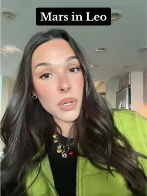 A woman with long dark hair and a light green jacket is centered in the frame, with a black box above reading "Mars in Leo."