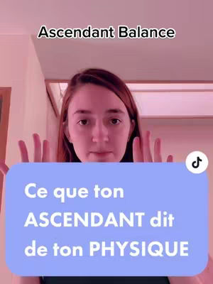 A woman with auburn hair is centered in the frame, her hands raised with palms facing the camera, as if presenting something. A light blue rectangle at the bottom contains white text. Above her head is a smaller black text on a pink background. The background is out of focus, suggesting an indoor setting.