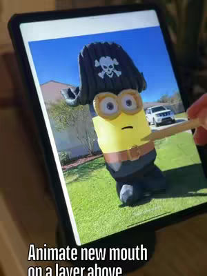 A tablet displaying a Halloween-themed animation of a Minion dressed as a pirate, with a house and car visible in the background.