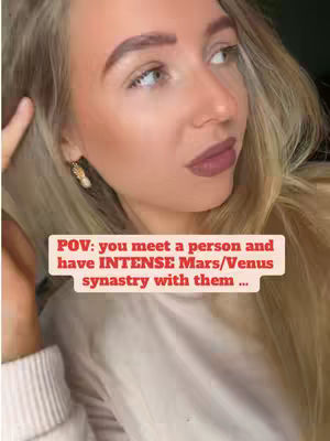 A close-up shot features a fair-skinned woman with blonde hair. She is looking off to the side, seemingly lost in thought. Her eyebrows are carefully shaped and darkened. The woman is wearing subtle makeup, including a mauve lipstick. A text overlay in the bottom center of the image reads: "POV: you meet a person and have INTENSE Mars/Venus synastry with them ..."