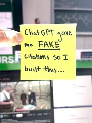A hand holds a yellow sticky note, with text written on and the screen on a device in the background.