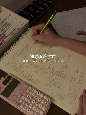 A top-down shot of a person's hand writing in a spiral notebook. Beside the notebook is a pink calculator and a pencil with a yellow grip. Text overlayed on the image reads 'studytok core' with various icon emojis below.