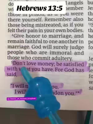 A page from a Bible is open, with the passage Hebrews 13:5 highlighted and annotated. A blue plastic device, possibly a pen or stylus, points towards the text. The overall composition is focused on the text, suggesting a study or devotional setting.